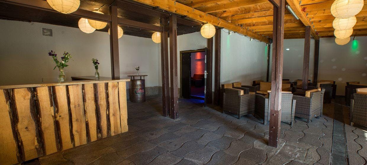 Rustic event space with wooden bar and cozy seating for networking gatherings.