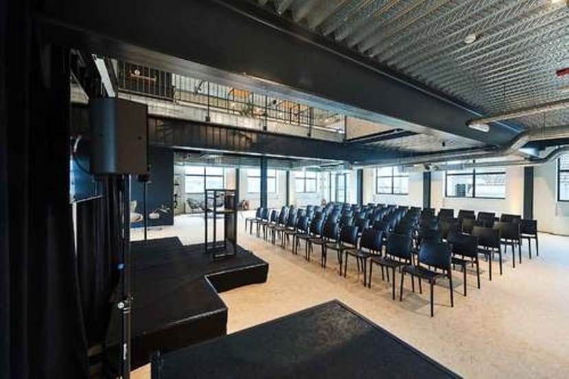 Versatile event space in Quartier Papier with stage and modern seating for conferences.