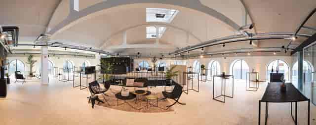 Modern event venue with high ceilings, perfect for networking and workshops.