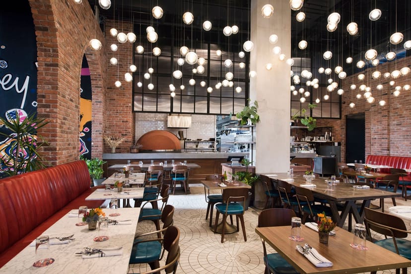 Vibrant Arlo Williamsburg ballroom with warm brick walls, perfect for events and celebrations.