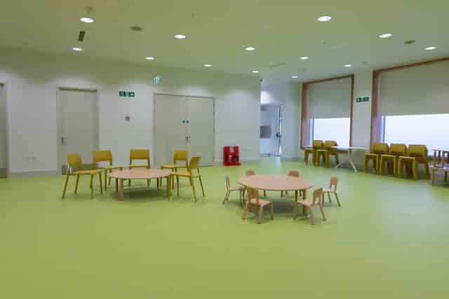 Versatile meeting space with round tables and colorful chairs for workshops at Una Marson Library.