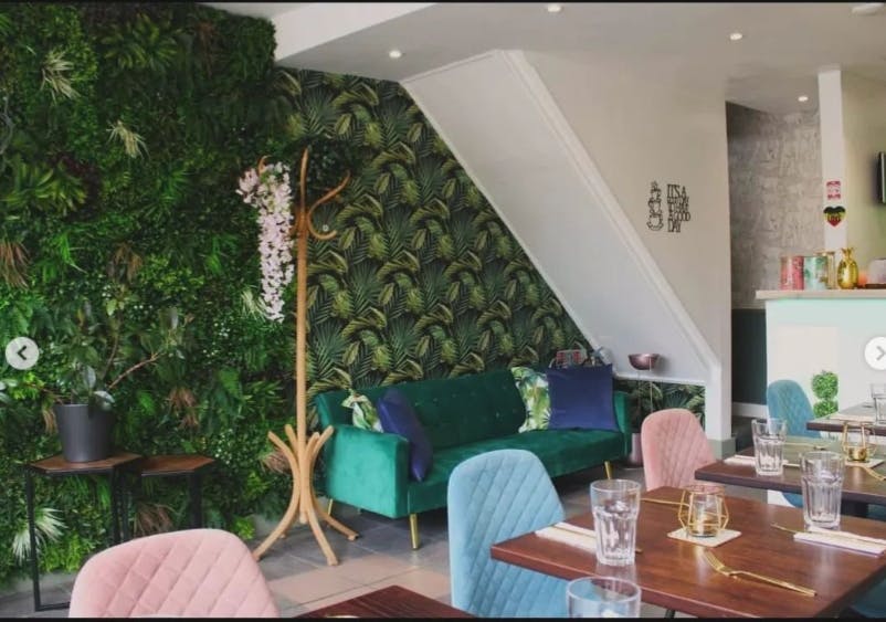 Vibrant event space at Audrey's Jamaican Restaurant with lush greenery and stylish furniture.