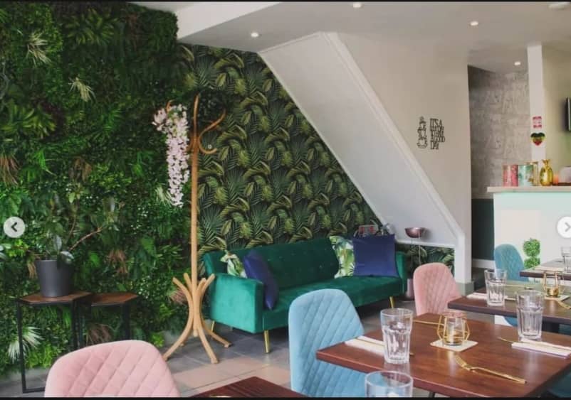 Vibrant event space at Audrey's Jamaican Restaurant with lush greenery and stylish furniture.