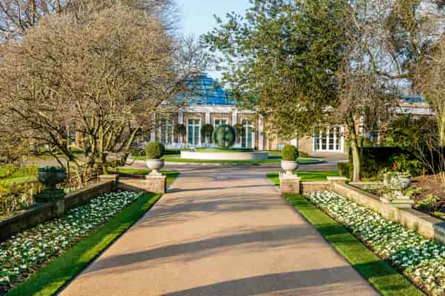 Grand entrance at The Hurlingham Club with symmetrical landscaping for corporate event receptions.