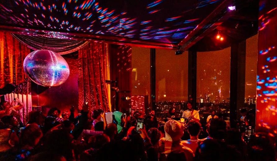 Vibrant event space at The Standard, London with disco ball and city view for celebrations.
