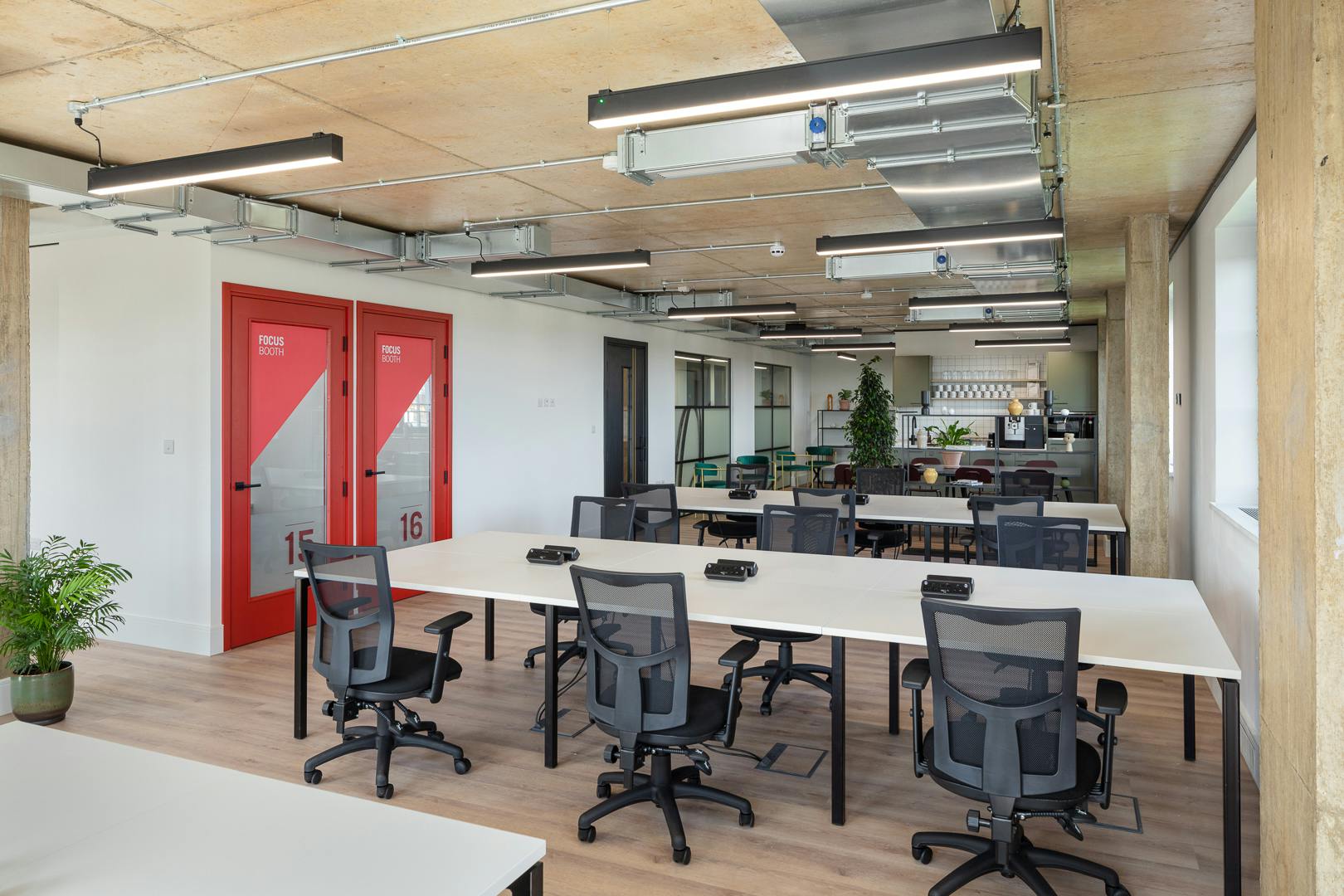 Modern private office with vibrant red doors for collaborative meetings at Riley Studios.