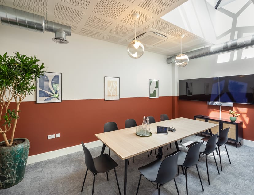 Modern meeting room with wooden table and black chairs for collaborative sessions.