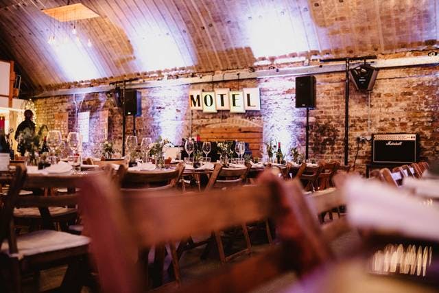 Rustic wedding venue with wooden tables and warm lighting at MOTEL Studios.