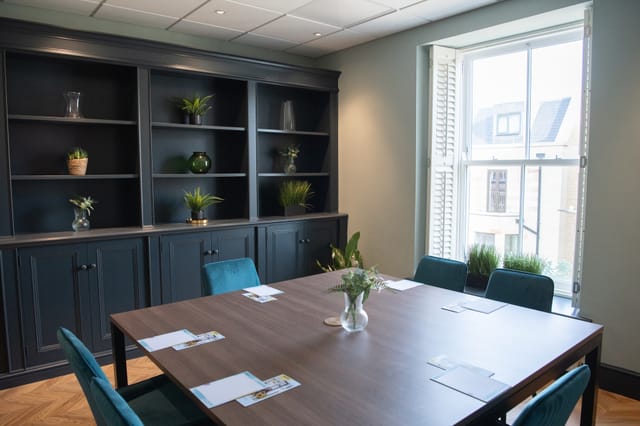 Oval Suite meeting room with natural light, perfect for brainstorming and small conferences.