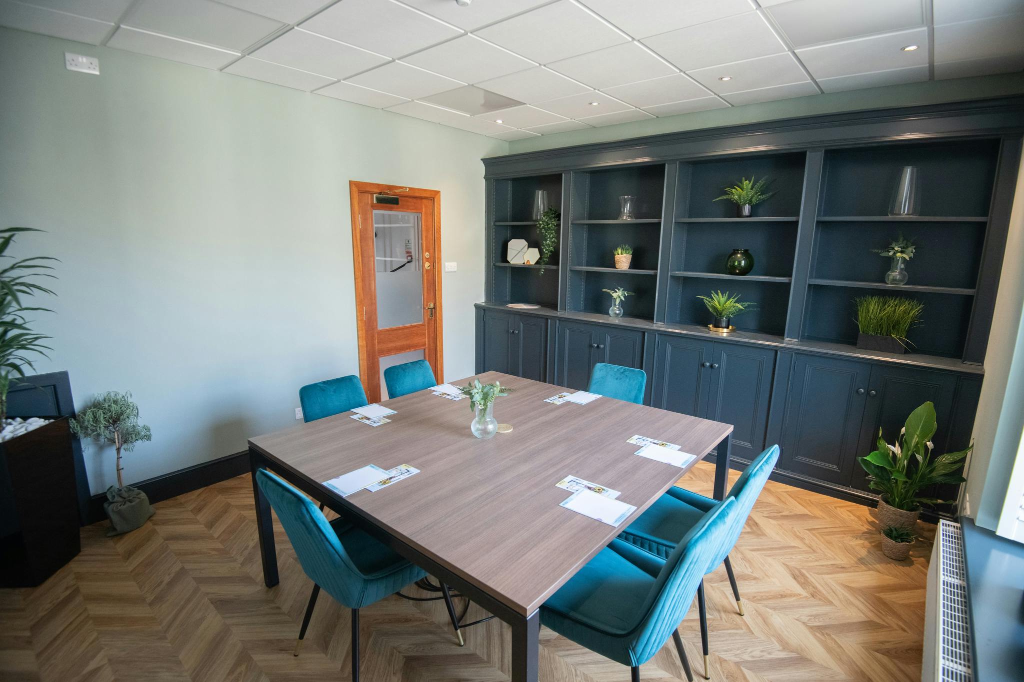 Oval Suite meeting room with teal chairs, perfect for workshops and brainstorming sessions.