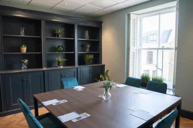 Oval Suite meeting room with sleek table setup for professional gatherings and brainstorming.