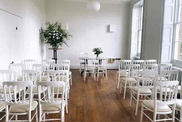 Minimalist event space with white chairs for meetings in Hackney Venues.