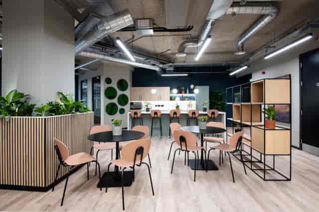 Modern meeting space with circular tables and greenery for networking events.