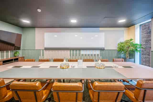 Modern meeting room in Wizu Workspace with large table and presentation screen.