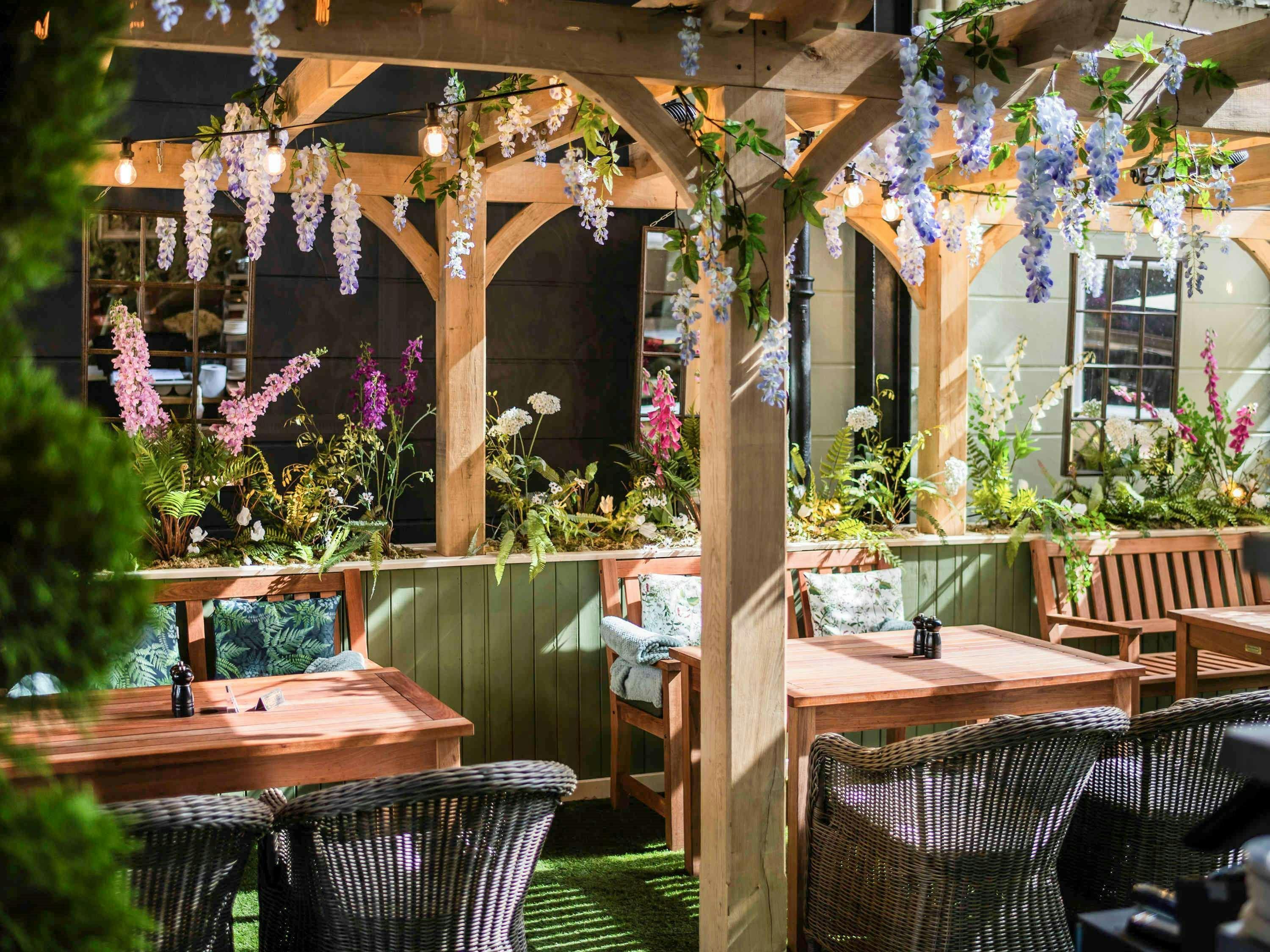 Outdoor event space at The Castle Hotel Windsor with vibrant flowers and cozy seating.