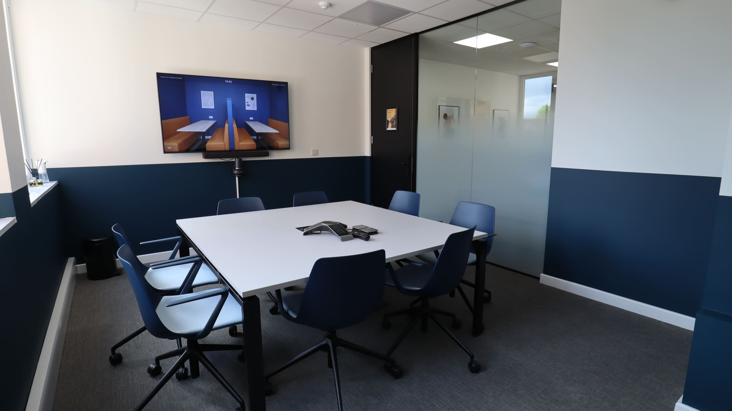 Modern meeting room with ergonomic chairs for collaboration at Common Ground Co Working. - Banner
