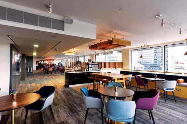 Modern meeting room in Etc.venues Manchester with colorful chairs, ideal for events.