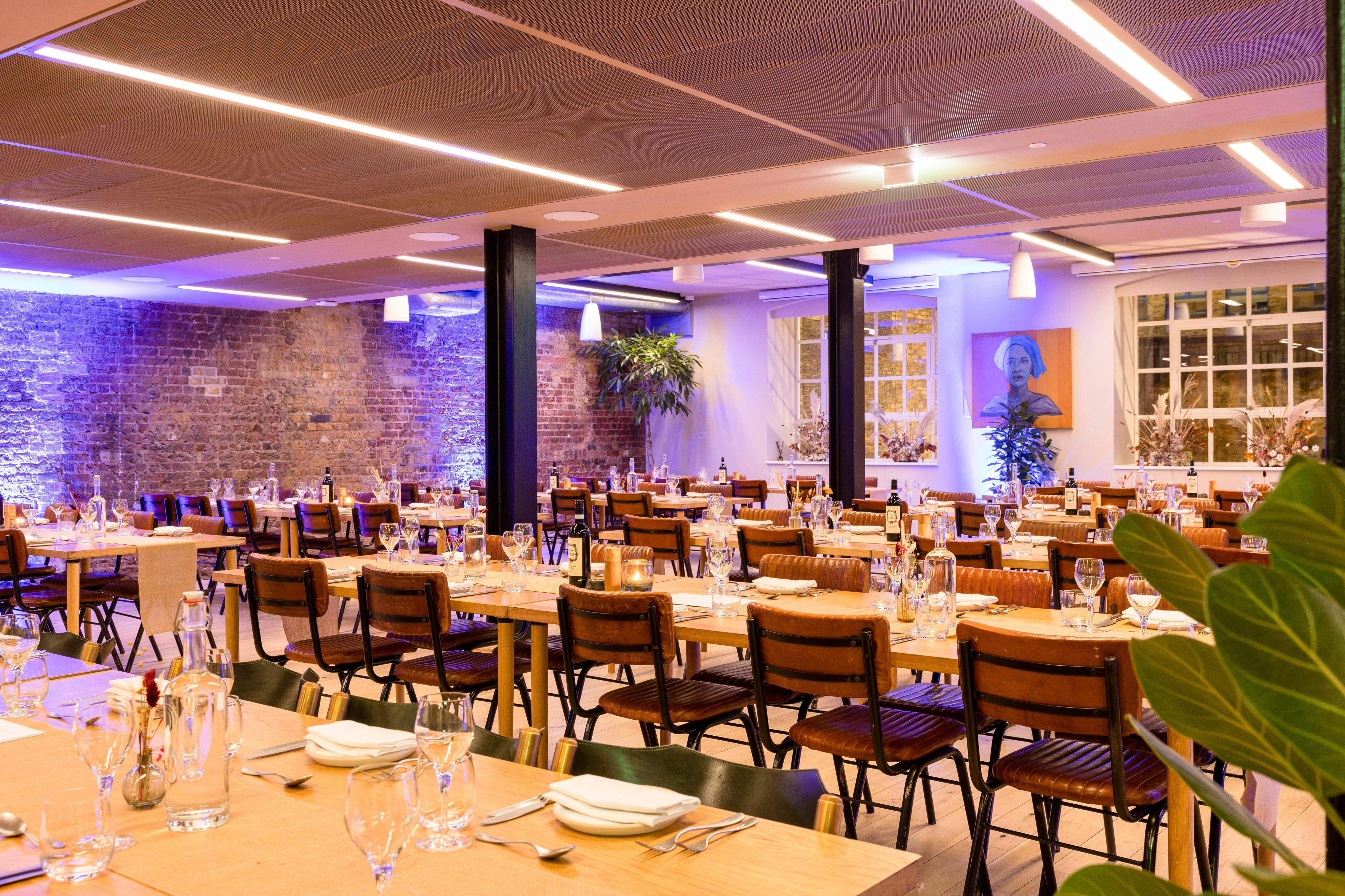 Stylish dinner event space at The Forum, featuring elegant communal tables and warm lighting.