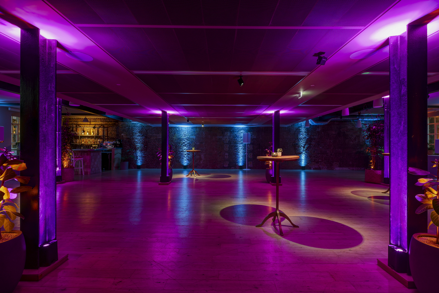 Stylish event space at The Forum with vibrant purple lighting for corporate gatherings. - Banner