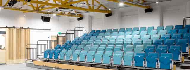 Modern auditorium with tiered blue seating for presentations and workshops.