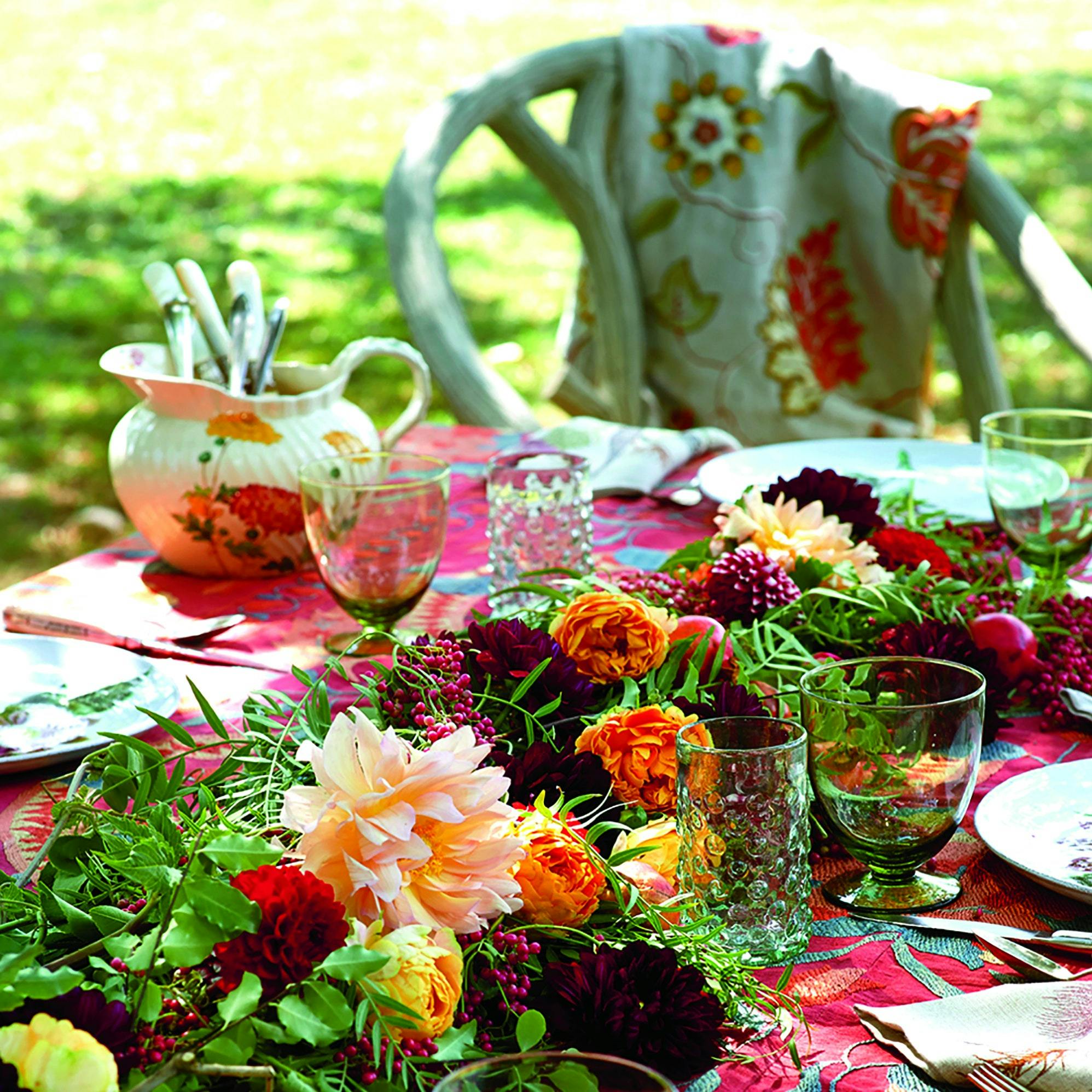 Elegant outdoor dining table with floral centerpiece for weddings and garden parties.