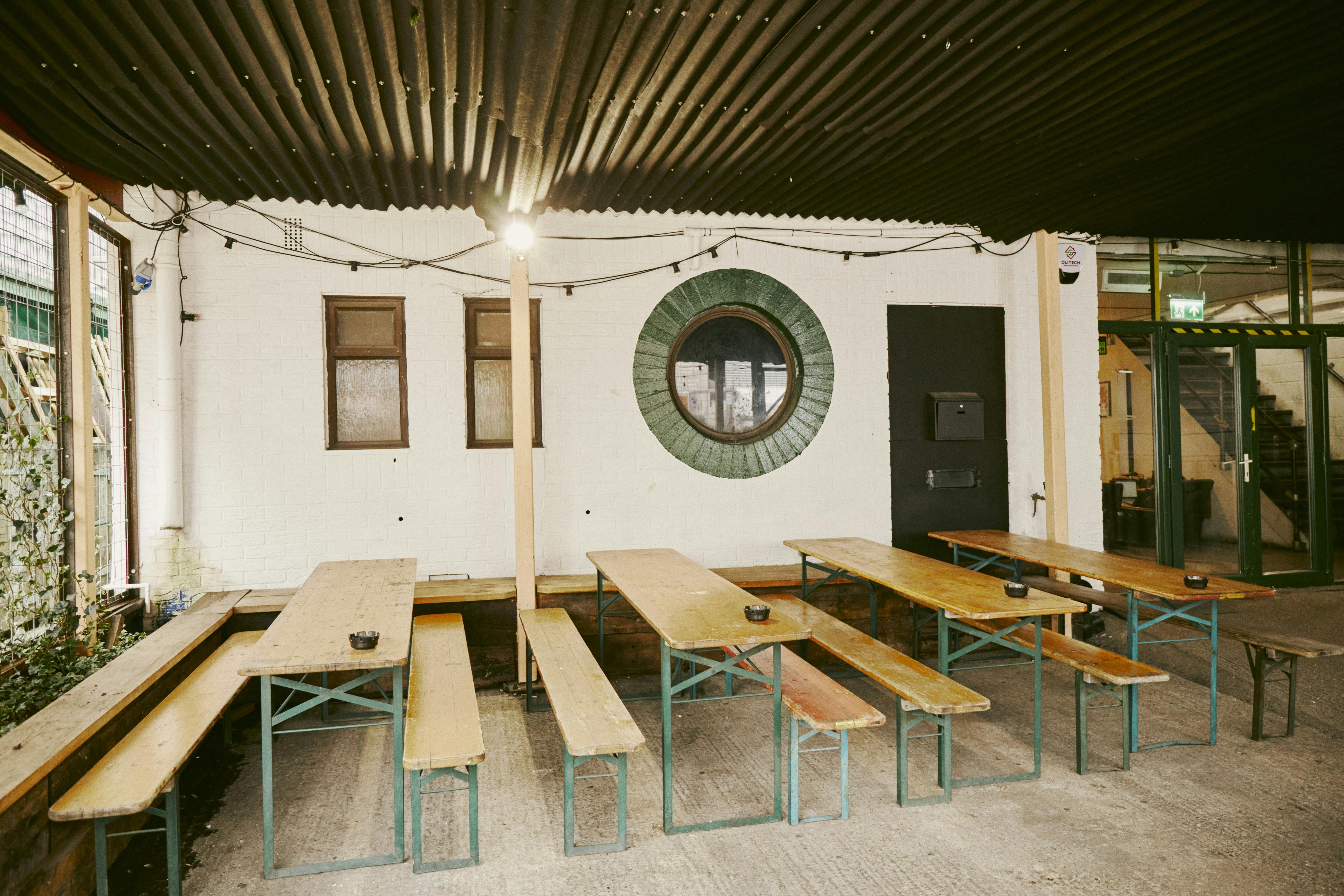 Hackney Wick Hangout at The Cause: industrial event space with wooden benches for gatherings.