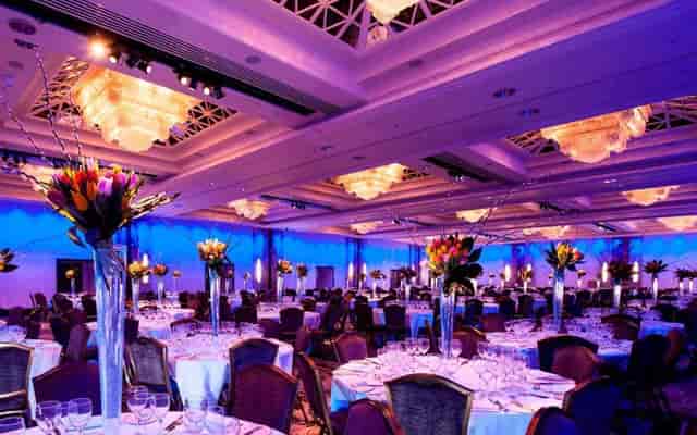 Royal Lancaster London luxury ballroom gala with purple uplighting and crystal chandeliers.