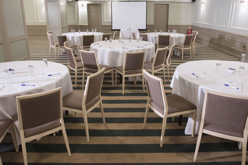 Cromwell Suite meeting space with round tables, perfect for workshops and conferences.