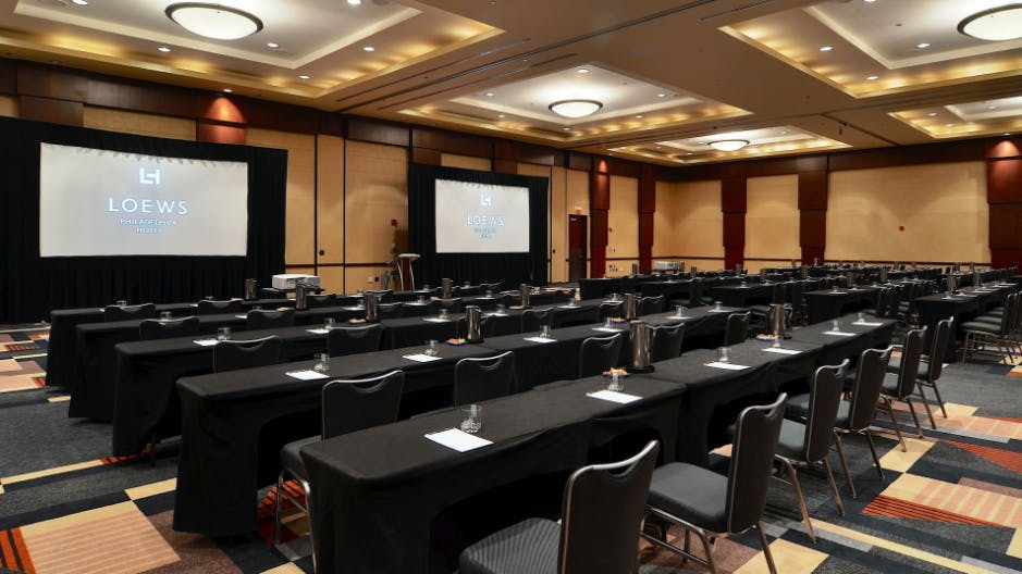 Conference room at Loews Philadelphia Hotel with tables and screens for corporate events.