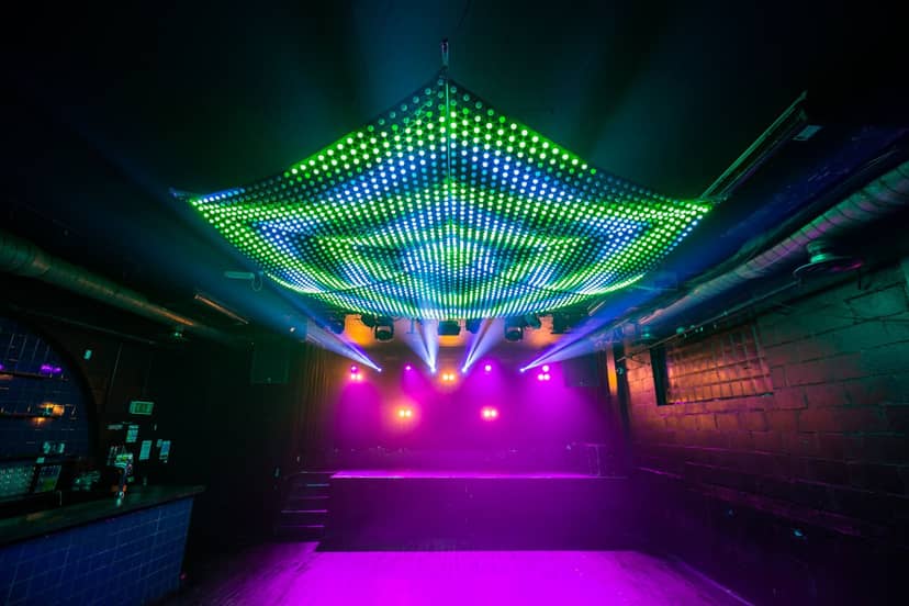 Vibrant Multiroom Event Space with LED lights, perfect for live performances and dance events.