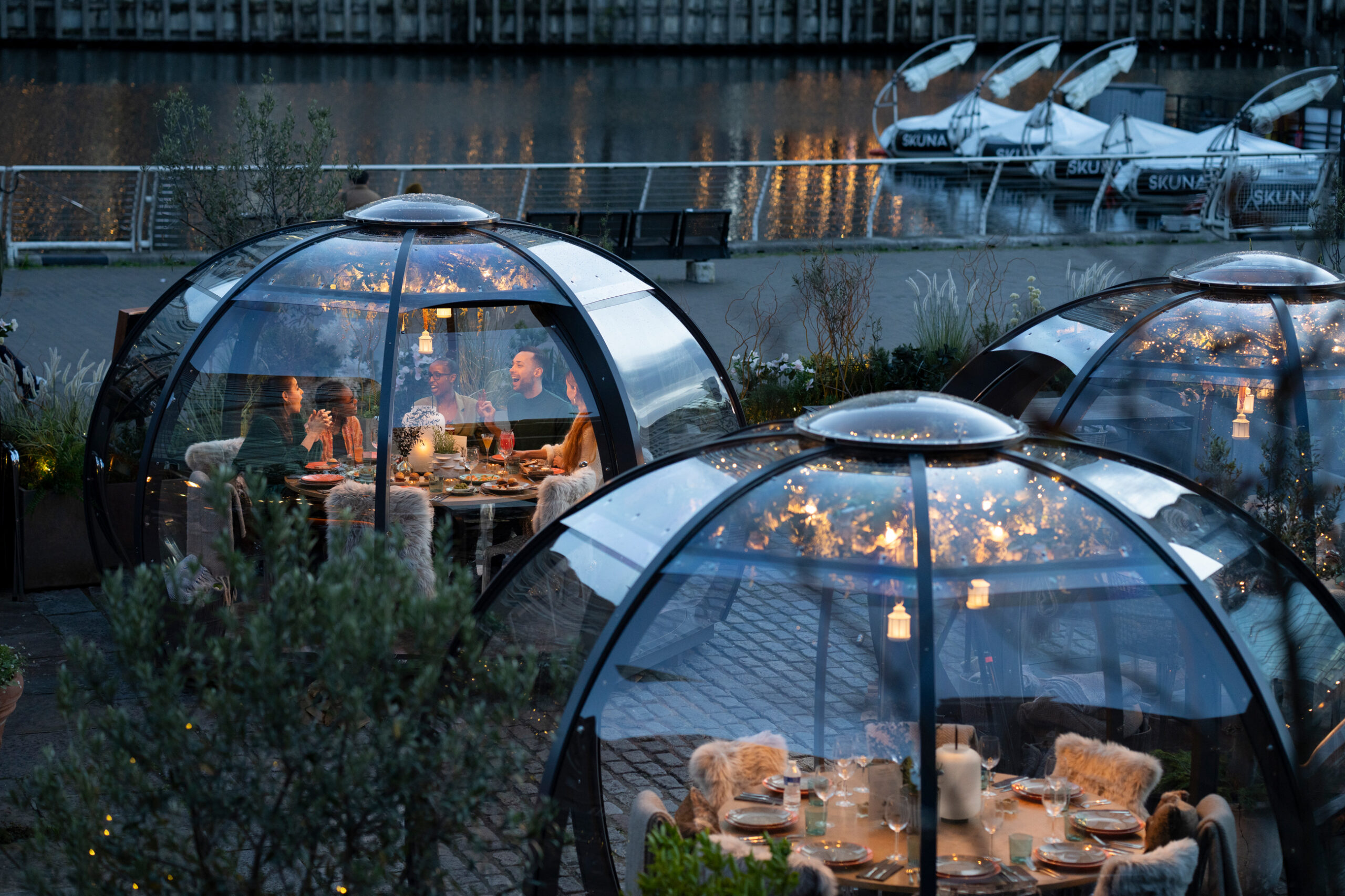 Outdoor dining with transparent domes at The Sipping Room for events and gatherings. - Banner