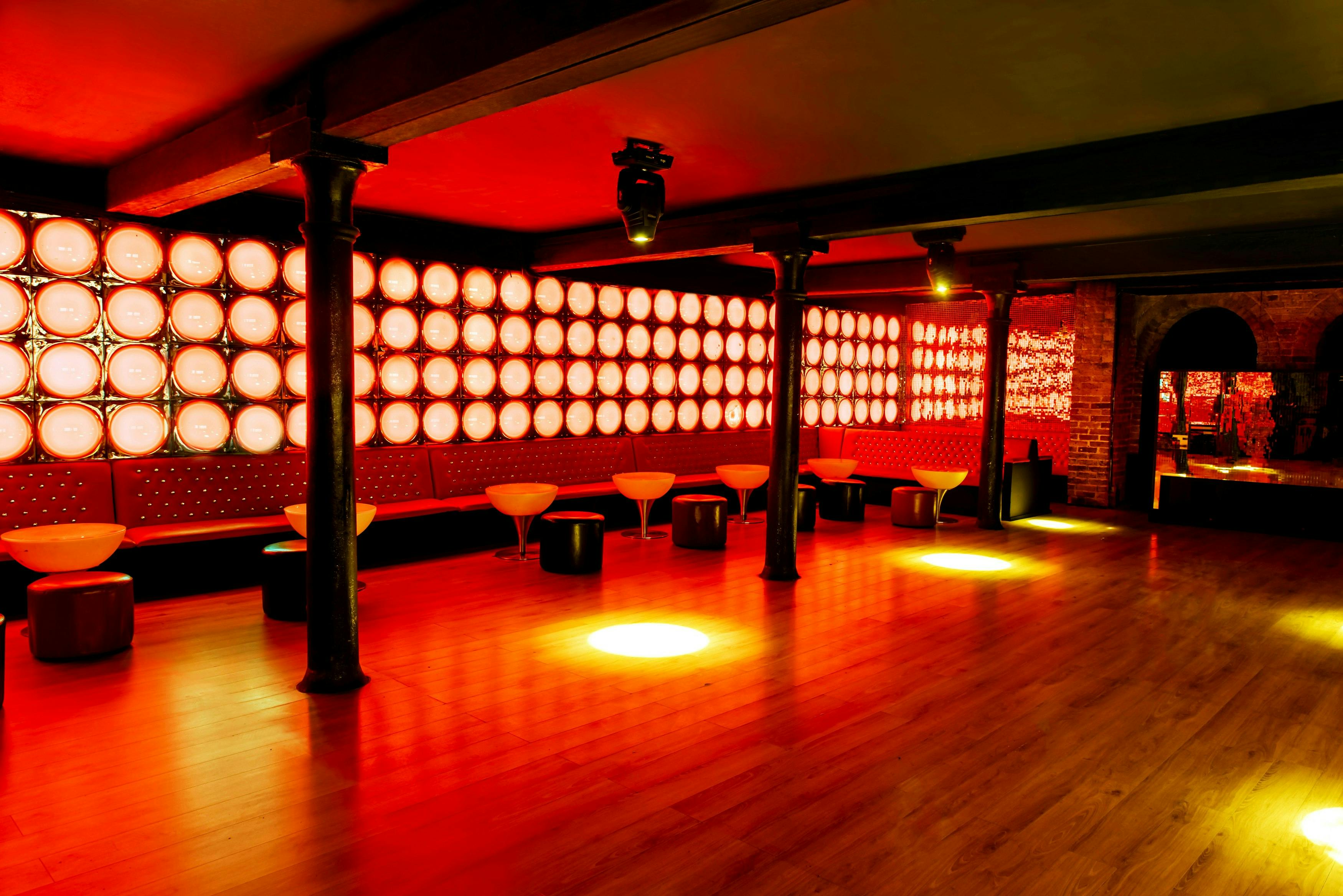 Stylish red event space with sleek seating, ideal for networking and social gatherings.