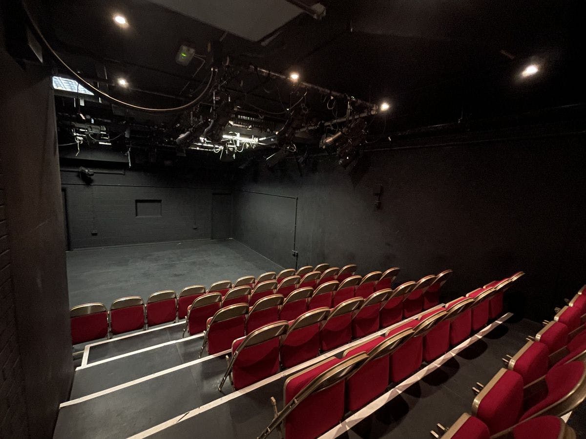 Seven Dials Playhouse black box theater with tiered red seating for intimate events.
