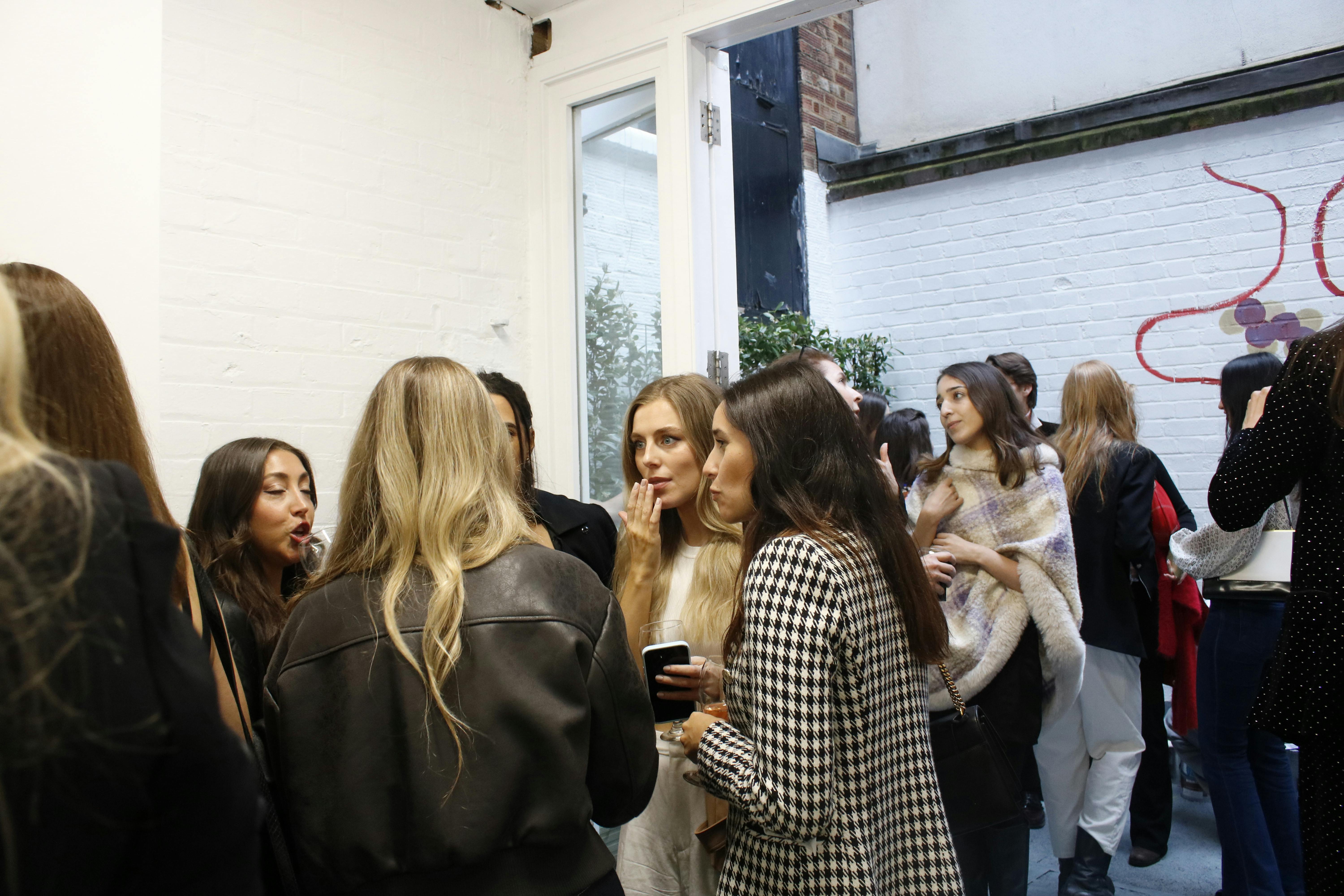 Vibrant networking event in Fitzrovia Gallery with stylish attendees and natural light.