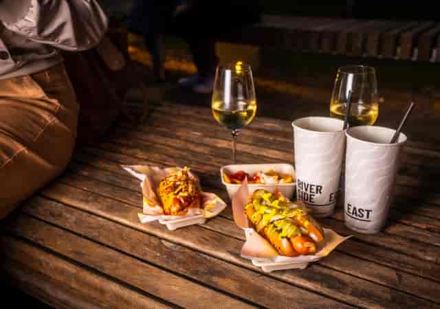 Outdoor dining setup at The Yard, featuring gourmet hot dogs for networking events.