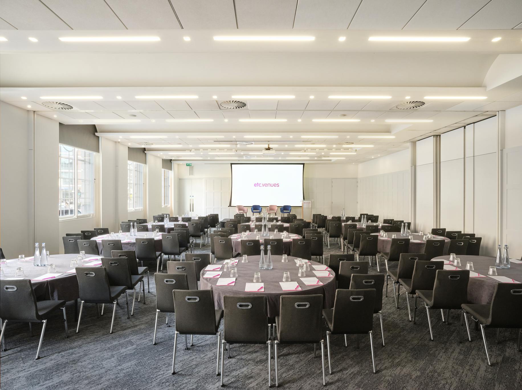 Illuminate Suite at Prospero House, featuring round tables for corporate events and presentations.