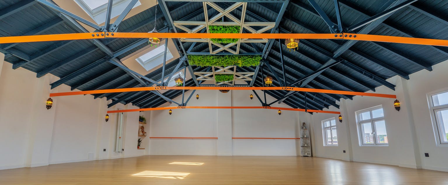 Spacious Highvibe event space with vibrant beams, ideal for workshops and meetings.