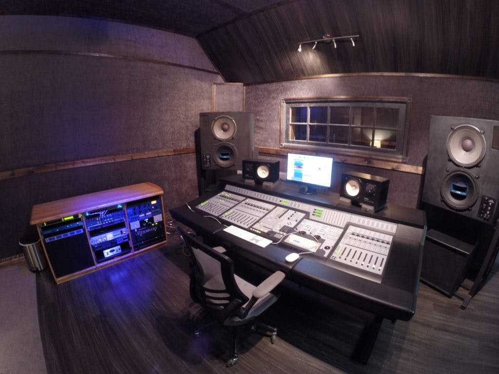 Professional audio control room with sleek mixing console for high-quality sound production.