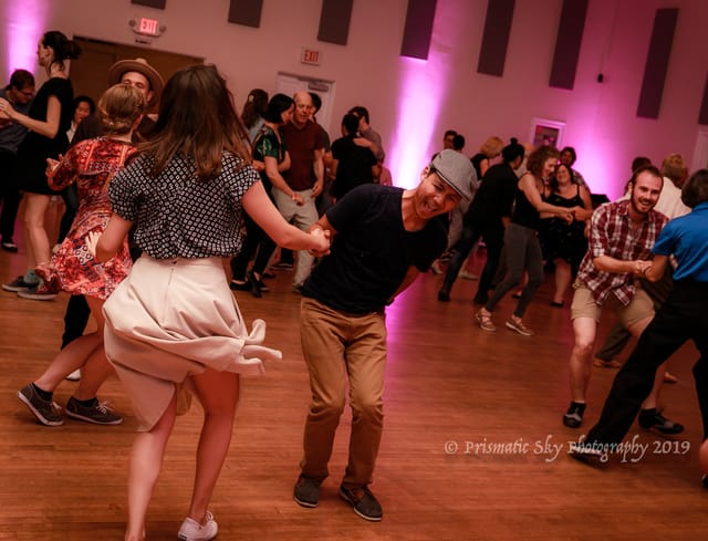 Vibrant dance event at Champion Ballroom with dynamic lighting and lively crowd.