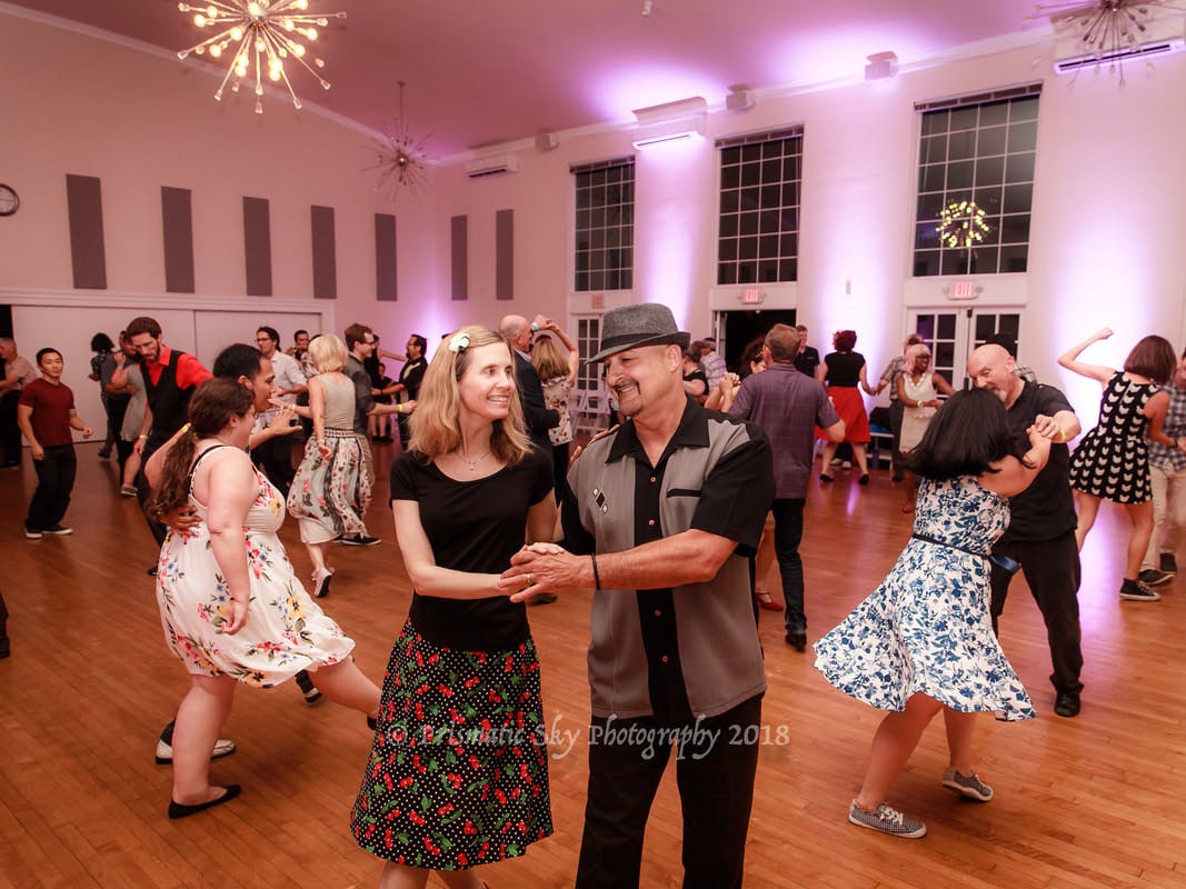 Vibrant dance hall at Firehouse Swing Dance with lively attendees and inviting atmosphere.