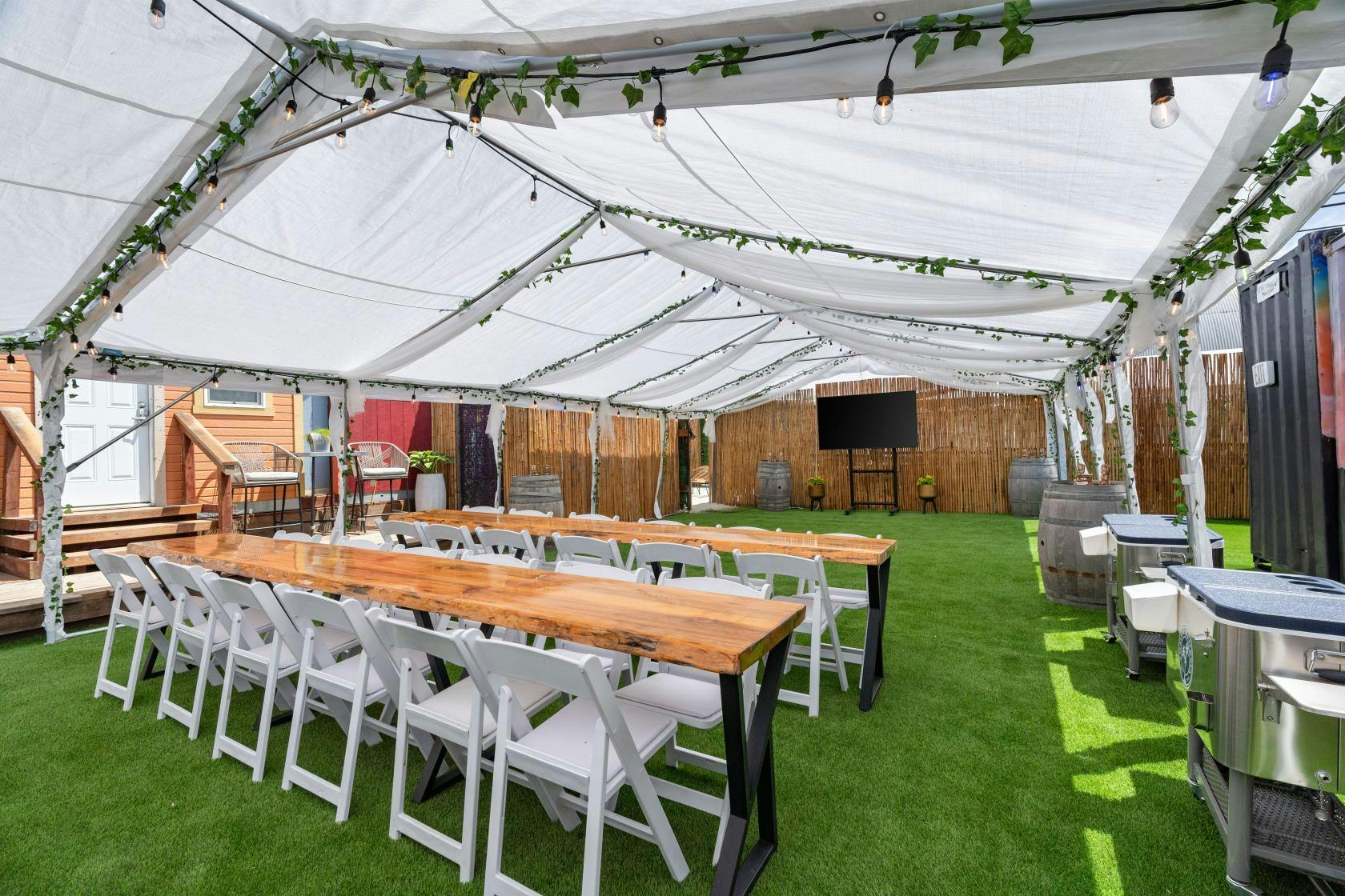 Outdoor event space with tent, string lights, ideal for gatherings and celebrations.