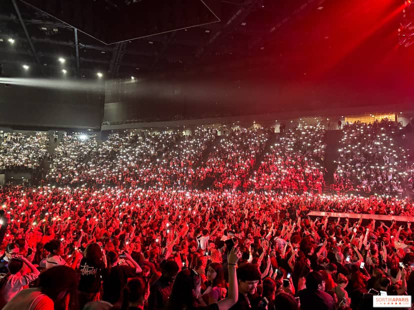 Packed Accor Arena with vibrant red lights, perfect for concerts and events.