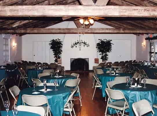 Banquet Hall with teal tables and rustic beams, ideal for events and gatherings.