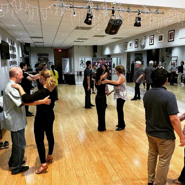 Lively ballroom dance class in spacious studio for team-building and social events.