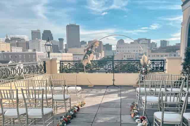 Elegant outdoor wedding ceremony at The Rooftop on Basin with city skyline backdrop.