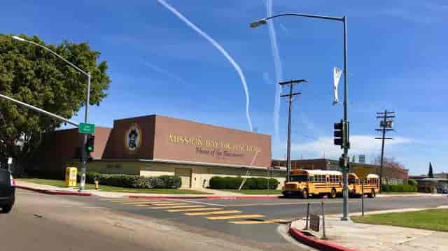 Mission Bay High School exterior with yellow buses, ideal for community events and workshops.