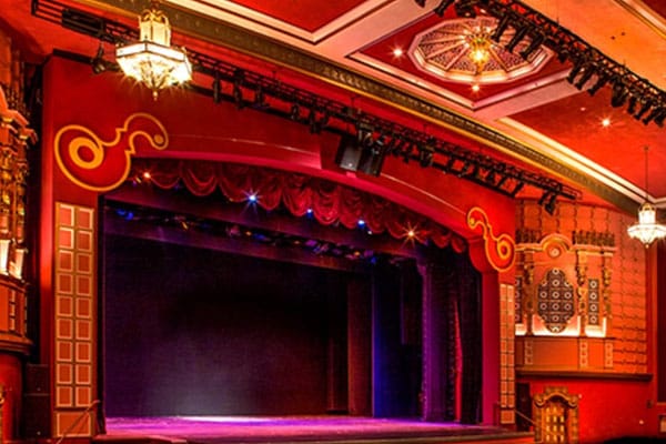 Elegant theater stage with red drapery at Music Hall, perfect for events and performances.