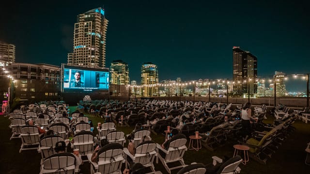 "Outdoor movie screening with lounge chairs and city skyline at Cinema Under The Stars"
