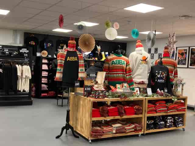Vibrant ABBA Voyage pop-up shop with colorful merchandise and festive decor.