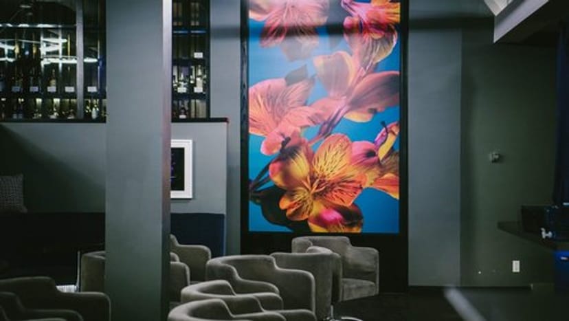 Private lounge with modern seating and vibrant floral art for stylish events.